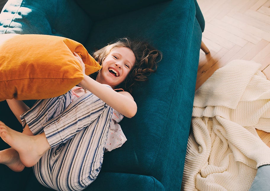 young girl laughing on couch