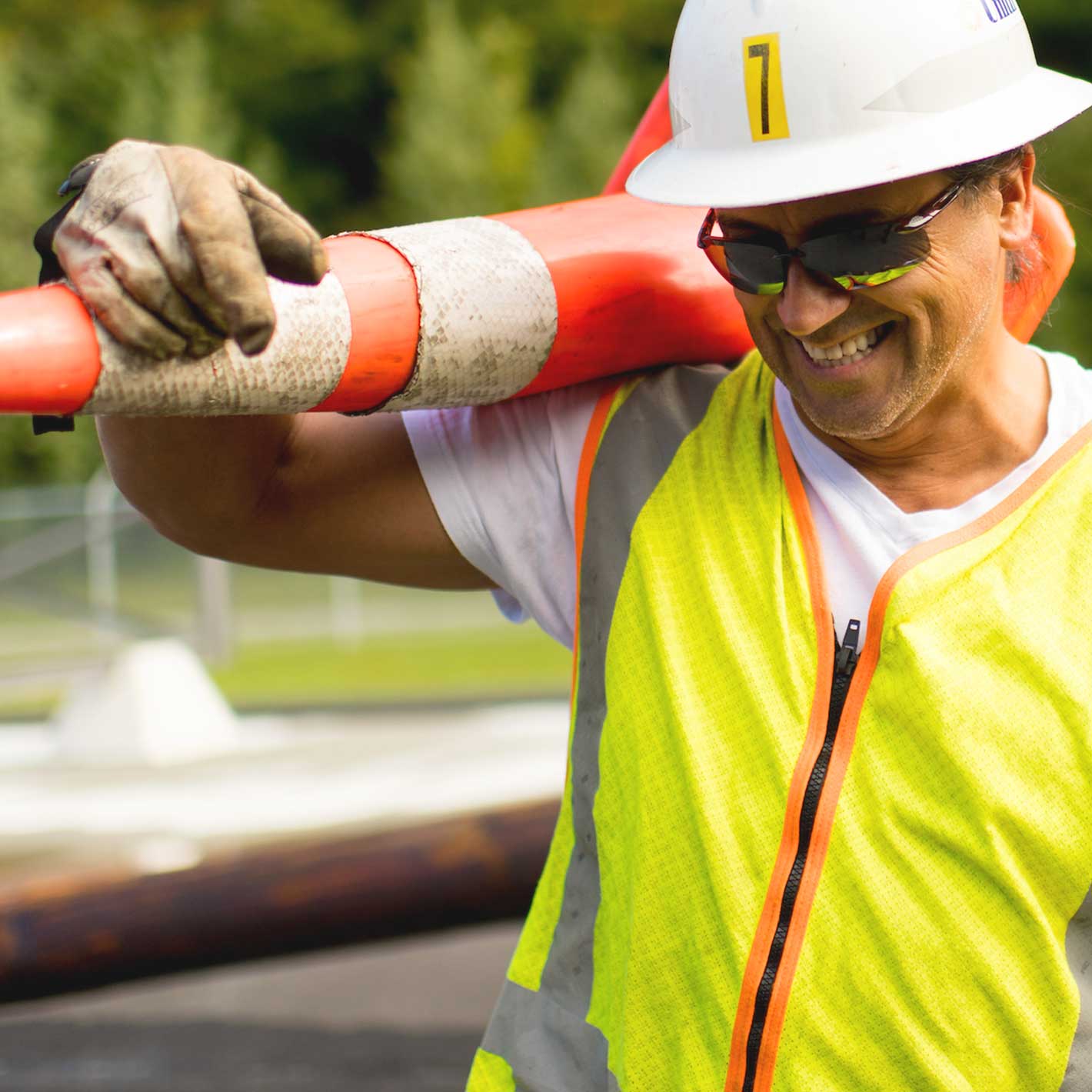Unitil line worker holding cone and smiling
