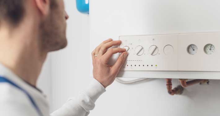 Man adjusting wall thermostat
