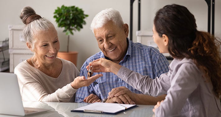 landlord handing keys to elderly couple