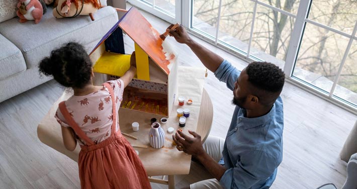 dad and daughter working on a doll house