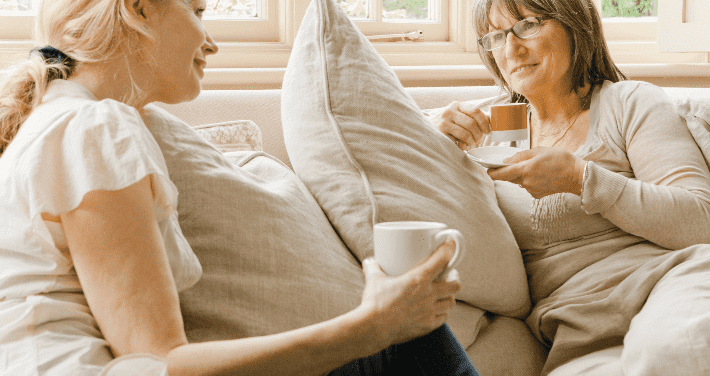 women on couch drinking coffee