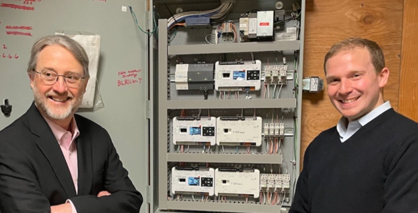 two people standing next to new electrical equipment