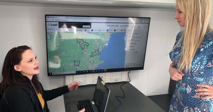 two women review the outage map at mobile command center desk