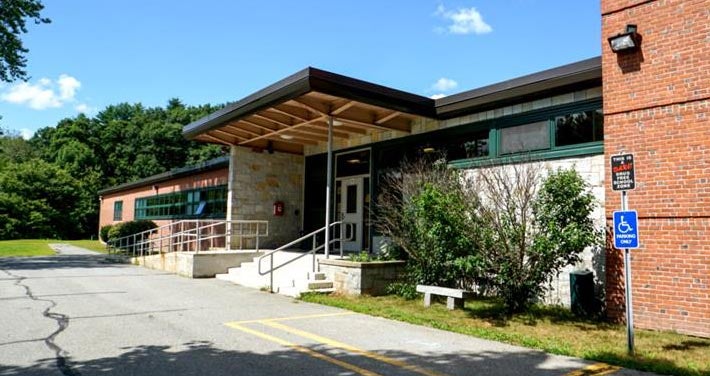 brick exterior of Ashby school main entrance with stairs and trees