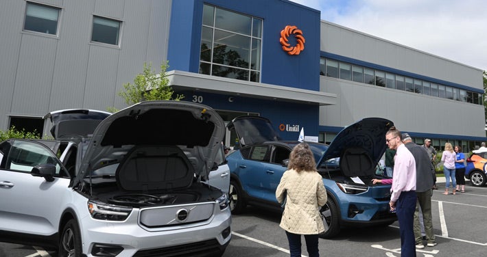 ev cars with their hoods popped in front of Unitil's Exeter building