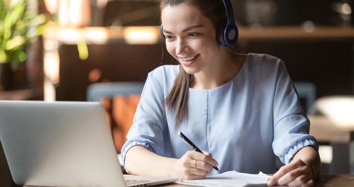 woman with headphones in front of a computer