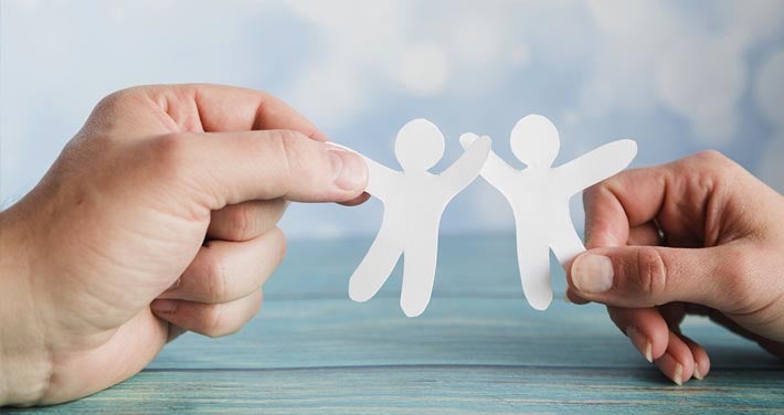 hands holding paper cutouts shaped like people