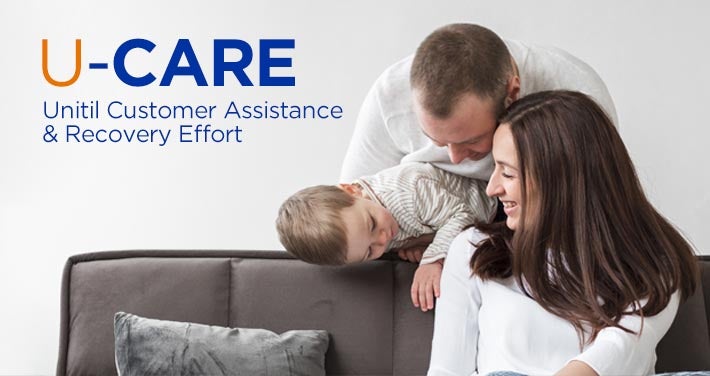 mother and father smile at their son on couch