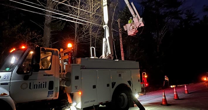 lights shine in the night from a Unitil bucket truck making repairs