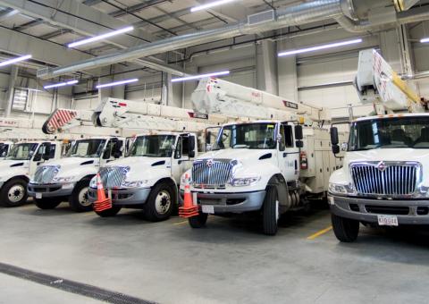 Unitil electric trucks lined up in warehouse