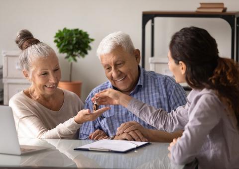 woman handing keys to elderly couple