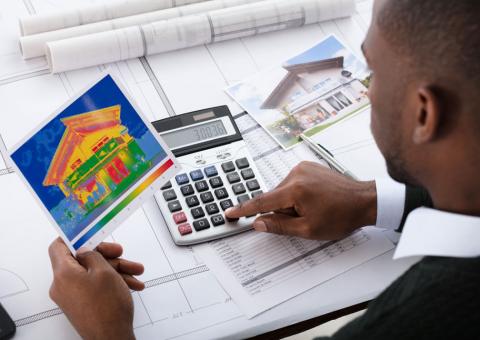 man with calculator and energy audit heat map