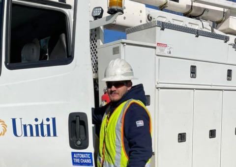 man in hardhat stands in front of parked Unitil truck