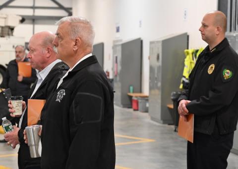 Local emergency officials listening to Sankowich in garage of Exeter facility