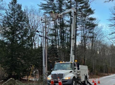 Lineman in bucket truck with arm extended. 