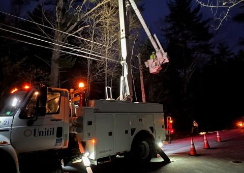 lights shine in the night from a Unitil bucket truck making repairs