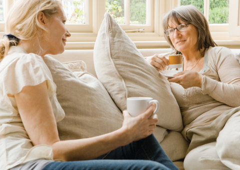 women on couch drinking coffee