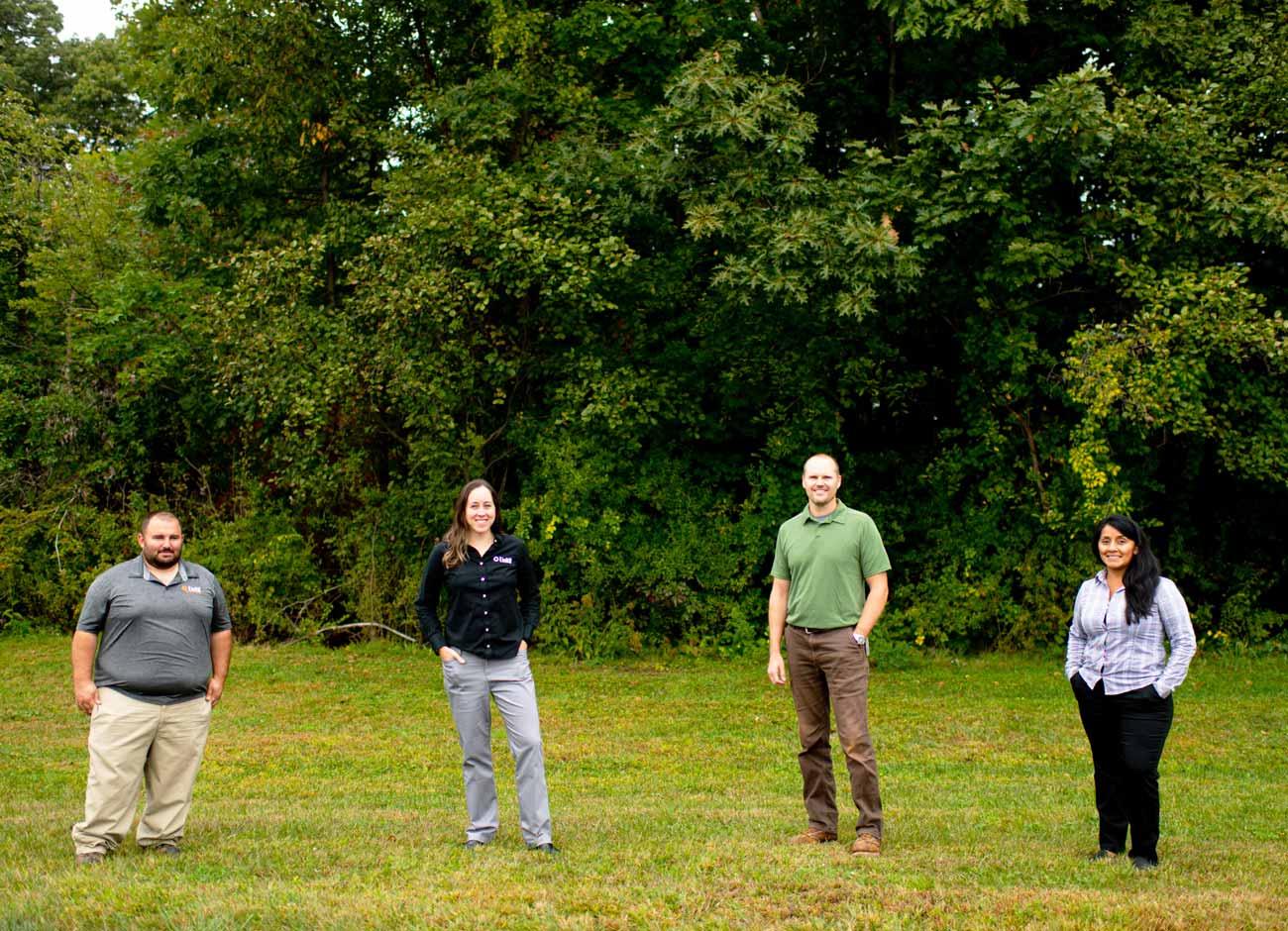 Unitil Forestry Team standing in field with trees in background